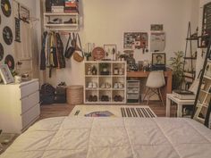 a bed sitting in a bedroom next to a white dresser and book shelf filled with books