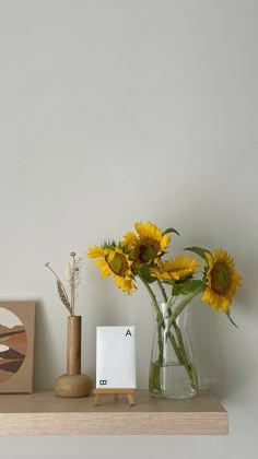 sunflowers are in a vase on a shelf