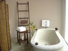 a large white bath tub sitting next to a wooden ladder