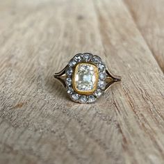 What a ring! This beauty features a 1.78 carat light yellow elongated old mine cushion cut diamond with a very tall crown. Approximately SI1 clarity. It is set in an 18k yellow gold milgrain bezel and surrouded by an additional .51ctw of rose cut diamonds set in silver. The double wire split shank is 14k yellow gold. The 18k bezel really makes the center stone pop and enhances the color to look fancy yellow.  Finger size: 7.5 and sizable. Message me if you need a quote. Diamond measurement: 8.2 x 6.3 x 4.47mm Overall meaurements: 13.66 x 10.99mm with a 4.9mm rise off the finger due to the super awesome ring-pop crown. The shank measures 2.22mm.  2.8 grams