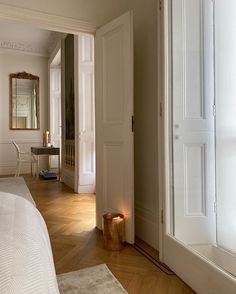 an image of a bedroom with white walls and wood floors