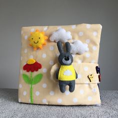 a stuffed animal sitting on top of a pillow next to a sun and cloud decoration