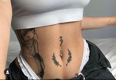 a woman's stomach with tattoos on it and an arrow in the bottom right corner