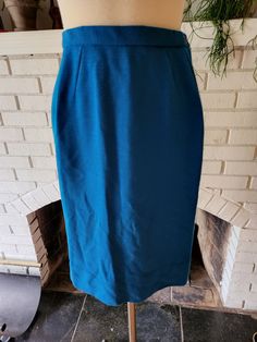 "Here is a lovely little skirt. It feels like polyester or a blend. Rich teal blue color with subtle pleats around the waist. Buttoned back with a 7\" zipper. Medium weight, slightly sheer, soft, and comfy. It's in amazing condition with tons of life left! The tag says Size 14, but here are the measurements taken laying flat (be sure to reference the last photo to see how I measure dresses) Waist 13\" Hips 19\" Length 23\"" Blue Skirted Bottoms With Pleated Waist, Blue Skirt With Pleated Waist And Relaxed Fit, Blue Pleated Waist Bottoms For Work, Blue Skirt With Pleated Waist, Fitted Blue Pleated Skirt With Lining, Fitted Blue Pleated Skirt With Lined Skirt, Blue Full Skirt With Pleated Waist, Fitted Blue Pleated Skirt For Work, Fitted Blue Pleated Lined Skirt