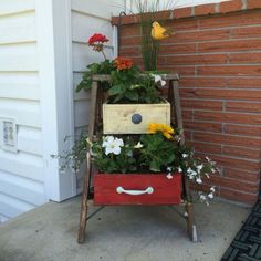 an old ladder is used as a planter with flowers and plants in it on the front porch