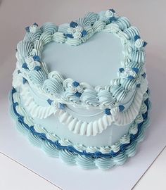 a heart shaped cake with blue and white frosting