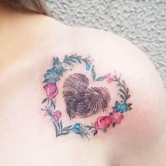 a close up of a person's shoulder with a fingerprint tattoo on it