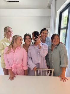 a group of women standing next to each other in front of a white counter top