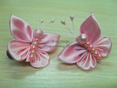 two pink flowers with pearls on them sitting next to each other in front of a wooden table