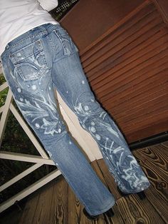 a person standing on a wooden floor with their back to the camera, wearing jeans and white t - shirt