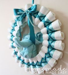 a blue and white wreath hanging on the wall with a stuffed elephant attached to it