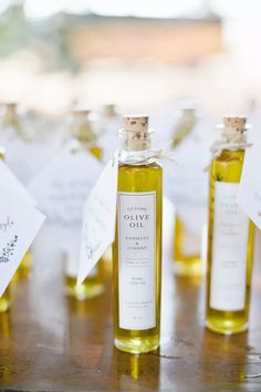 three bottles of olive oil sitting on top of a table