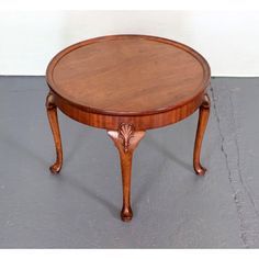 a small wooden table sitting on top of a gray floor