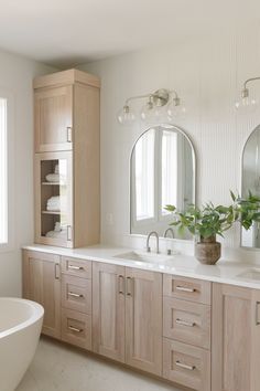 a bathroom with two sinks, mirrors and a bathtub in the middle of it