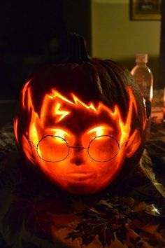 a pumpkin carved to look like harry potter with glasses on it's face and eyes