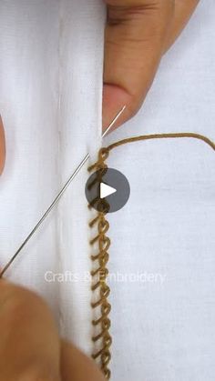 someone is stitching the thread on a white shirt