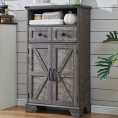 a wooden cabinet with two doors on the front and one door open to reveal towels