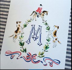 the letter m is painted on top of a card with an image of two horses and a dog