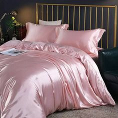 a bed with pink sheets and pillows in a room