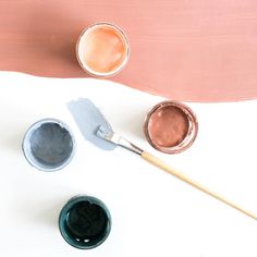 some paint and brushes on a white table