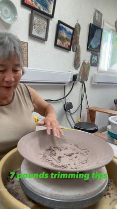 an older woman is working with clay on a potter's wheel