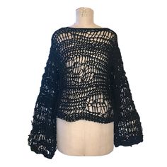 a black crochet sweater on a mannequin dummy with an open back