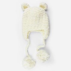 a white knitted hat with pom - poms