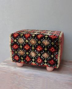 an artisticly designed box sitting on top of a wooden table next to a wall