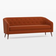 an orange couch sitting on top of a white floor