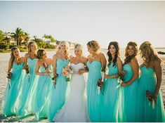 a group of women standing next to each other on a beach