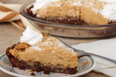 a piece of pie on a plate with a fork in front of it and another pie behind it