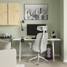 a white office chair sitting in front of a desk with a monitor and keyboard on it