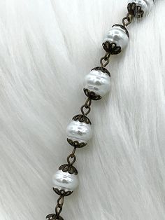 Are you looking for a beautiful rosary chain to add to your jewelry designs? Look no further than our Glass Pearl Beaded Rosary Chain! This chain is made with 9mm pearls and comes in five styles: white pearls with bronze wire, white pearls with silver wire, white pearls with gold wire, white pearls with matte gold wire, and rose dust pearls with bronze wire. It is sold by the foot, and multiple feet will come in a continuous strand. Plus, orders placed by 11:00 am EST Monday-Friday ship the same Chain Rosary, Hand Knotted Pearls, Rosary Chain, Brass Charms, Coin Pendant, Brass Chain, Vintage Porcelain, Matte Gold, Silver Wire