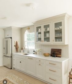 a white kitchen with lots of cabinets and counter space, including a refrigerator freezer