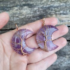 These highly polished natural Amethyst crescent moon shaped stones have been wrapped in silver and copper wire to form the tree of life, which represents peace and immortality. The handmade pendant measures 1-1/2" tall by 1-1/4" wide and will come on a matching color chain (silver, copper or rose gold) or a black leather cord in the length of your choice. Natural Amethyst stone is one of nature’s most potent amplifiers of inner peace, positive transformation, balance, and healing of body, mind and soul. Amethyst has also been known for protecting the wearer from nightmares and insomnia, which makes it the perfect healing gift for your friends and loved ones!Chain Type Options:If you want a Silver wire wrapped stone with silver color chain, Select (Silver Wire & Chain)If you want a Silver w Amethyst Moon Charm For Jewelry Making, Handmade Moon Shaped Amethyst Jewelry, Moon-shaped Amethyst Jewelry Gift, Purple Moon Shaped Spiritual Jewelry, Moon-shaped Amethyst Jewelry For Gifts, Mystical Crescent Amethyst Jewelry, Spiritual Purple Moon Shaped Jewelry, Spiritual Purple Moon-shaped Jewelry, Handmade Purple Crescent Jewelry