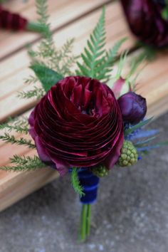 a bouquet of flowers sitting on top of a wooden bench