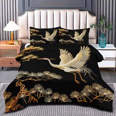 a black and gold bed set with two cranes on it