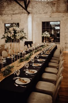 a long table is set up with white flowers and greenery for an elegant wedding reception