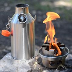 a stainless steel keg next to a fire pit with flames coming out of it