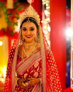 a woman dressed in red and gold is posing for the camera