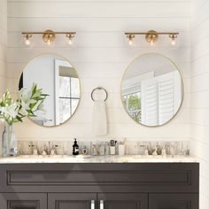 a bathroom with two round mirrors above the sinks