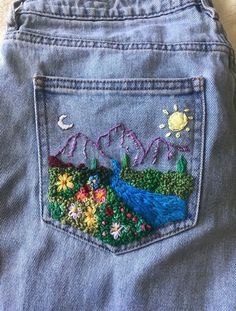 the back pocket of a pair of jeans with embroidered flowers and birds on them,