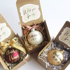 three personalized christmas ornaments in boxes on a table