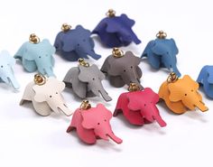 the elephant keychains are all different colors and sizes, but each has a gold bell