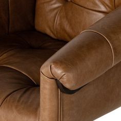 a brown leather reclining chair sitting on top of a white floor