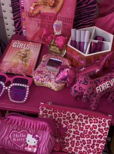 a pink table topped with lots of items