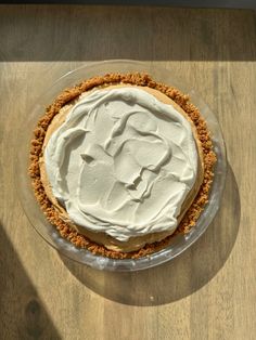 a pie sitting on top of a wooden table covered in frosting and crumbs