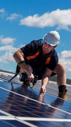 a man working on the roof of a solar panel