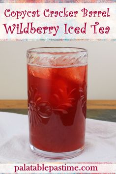 a glass filled with red liquid sitting on top of a table