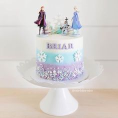 a frozen princess themed cake with figurines on top and the words briar spelled in frosting